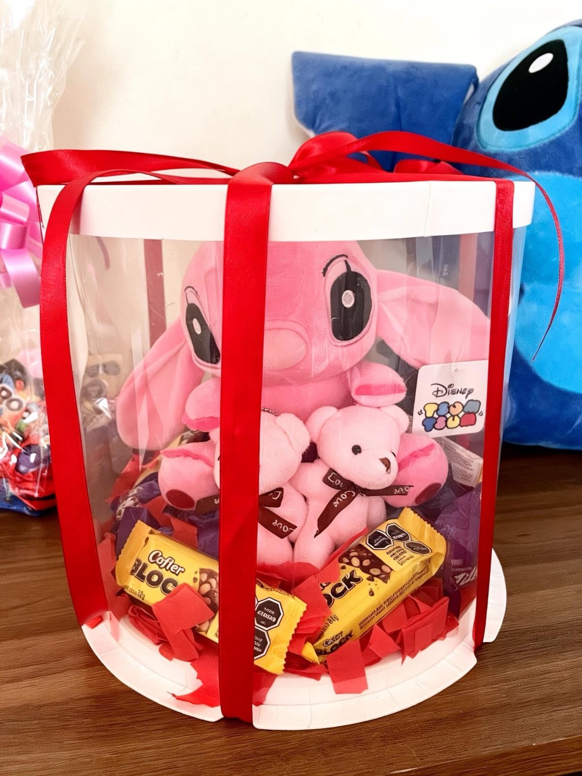 Caja cilindro transparente con peluche rosa y chocolates